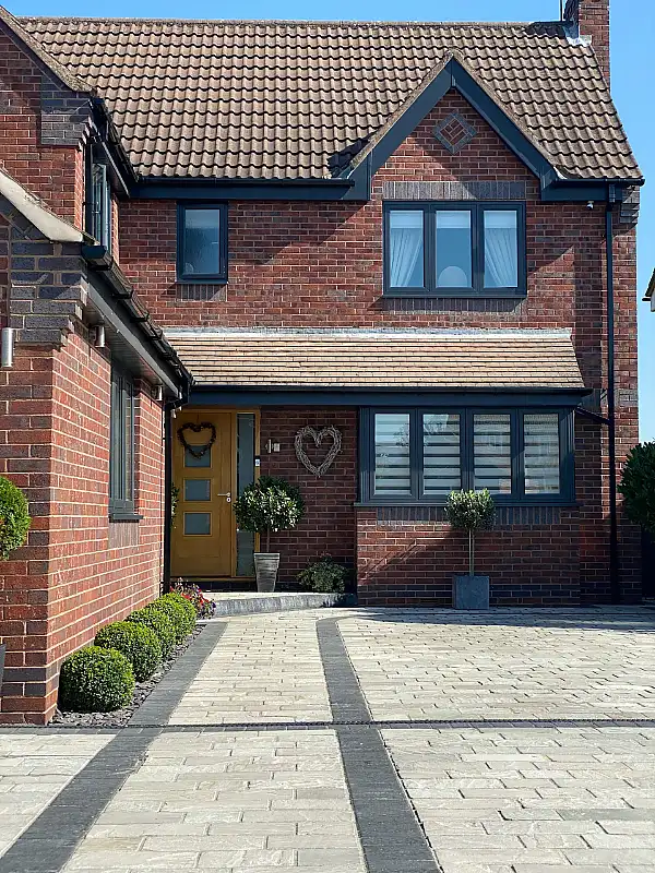 Paving stone driveway laid in front of a brick home