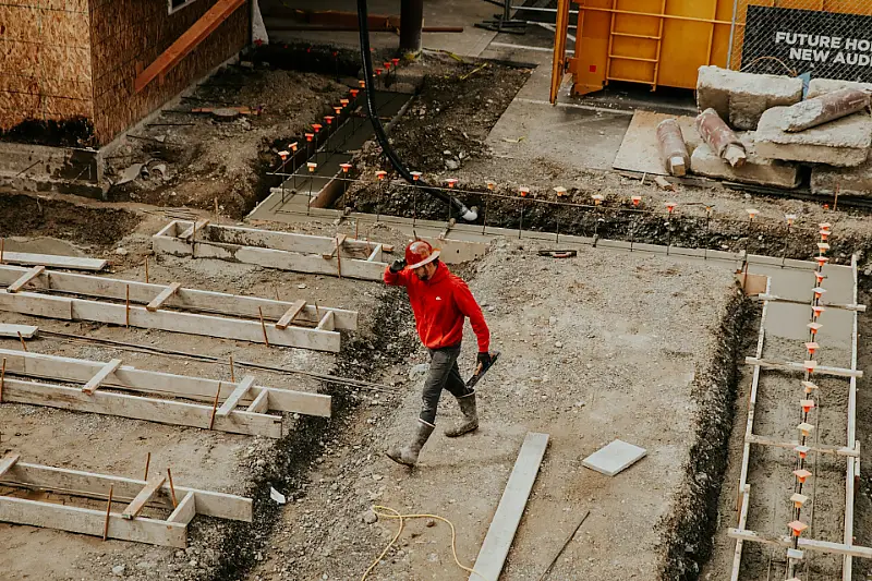 Overhead view of a worker on a site with concrete formwork and excavated ground prepared for pouring