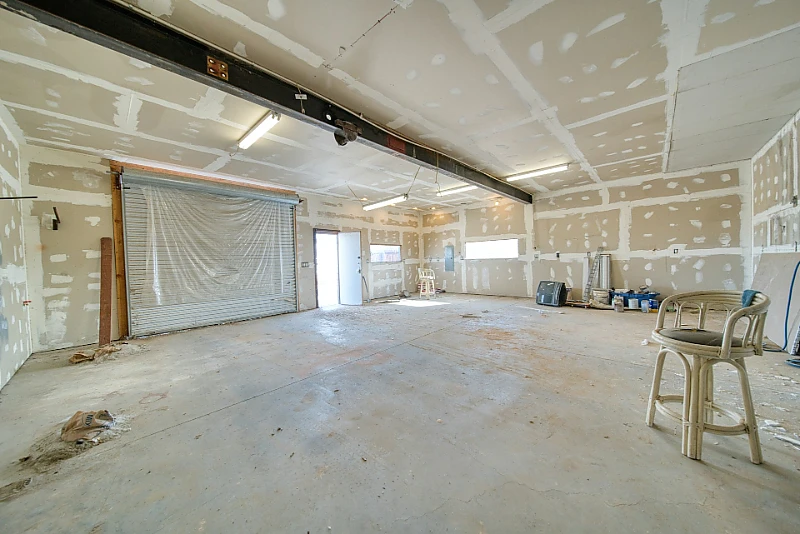Garage interior with drywall hung, taped, and mudded, ready for sanding