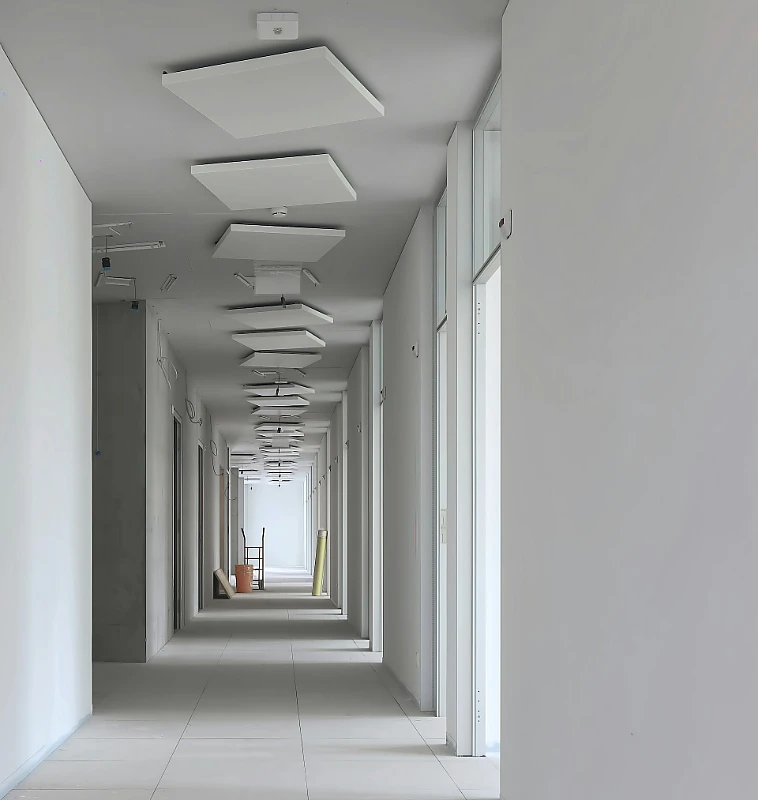 Long corridor with a smooth drywall finish and recessed square ceiling light panels